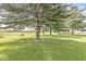 Secluded backyard with lush green grass and mature trees, creating a serene and private outdoor space at 523 Torrey Ct, Avon, IN 46123