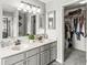 Bathroom vanity with double sinks, a large mirror, and access to a walk-in closet at 523 Torrey Ct, Avon, IN 46123