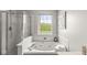 Close-up of a tub with jets, brightened by a window, and complete with a glass shower door at 523 Torrey Ct, Avon, IN 46123