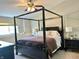 Bedroom features a dark wood four-poster bed with neutral bedding, side tables, and soft, natural lighting at 523 Torrey Ct, Avon, IN 46123
