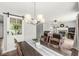 Dining room with a modern chandelier, table, and door with decorative wreath detail at 523 Torrey Ct, Avon, IN 46123