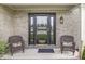 Inviting front entrance with a decorative glass door, brick facade, and charming wicker chairs at 523 Torrey Ct, Avon, IN 46123