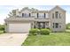 Charming two-story brick home featuring an attached two-car garage and a well-manicured front yard at 523 Torrey Ct, Avon, IN 46123
