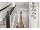 Hallway with hardwood floors, staircase, and a glimpse of the kitchen, offering a seamless flow at 523 Torrey Ct, Avon, IN 46123