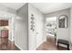 Bright hallway featuring hardwood floors, modern wall decor, and views into the living room and kitchen at 523 Torrey Ct, Avon, IN 46123