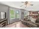 Living room with nice windows, ceiling fan, dark furniture and adjacent kitchen and dining areas at 523 Torrey Ct, Avon, IN 46123
