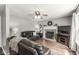 Living room with a cozy fireplace, ceiling fan, and dark brown leather furniture at 523 Torrey Ct, Avon, IN 46123