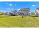 Large backyard with green lawn, black fence, and view of the community homes at 6305 Norwich Dr, Brownsburg, IN 46112