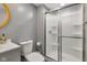 Well-lit bathroom with frosted glass shower, grey walls, modern white toilet and vanity at 6305 Norwich Dr, Brownsburg, IN 46112