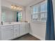Bathroom vanity with double sinks and a large window, plus dark vinyl flooring at 6305 Norwich Dr, Brownsburg, IN 46112