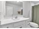 Bathroom featuring white vanity, toilet and hardware and grey wood look flooring and a green shower curtain at 6305 Norwich Dr, Brownsburg, IN 46112