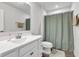 Bathroom featuring white vanity, toilet and hardware and grey wood look flooring with a green shower curtain at 6305 Norwich Dr, Brownsburg, IN 46112