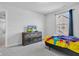 Neutral toned bedroom with grey carpet, window, blue curtains and bright yellow and multi-colored bedding at 6305 Norwich Dr, Brownsburg, IN 46112