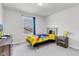 Cozy bedroom with bright yellow and multi-colored bedding with grey carpet, window and a wooden nightstand at 6305 Norwich Dr, Brownsburg, IN 46112