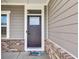 Close-up of the front door with brick accents and a colorful welcome mat at 6305 Norwich Dr, Brownsburg, IN 46112