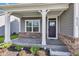 Covered front porch with brick accents, white columns, and view of the front yard and a partial view of the street at 6305 Norwich Dr, Brownsburg, IN 46112
