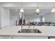 Open concept kitchen featuring stainless steel sink and pendant lighting, flowing into the living room at 6305 Norwich Dr, Brownsburg, IN 46112