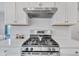 Modern kitchen with stainless steel gas range and hood; white cabinets and quartz countertops at 6305 Norwich Dr, Brownsburg, IN 46112