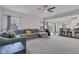 Bright living room with large sectional sofa, ceiling fan, and an open flow to the modern kitchen at 6305 Norwich Dr, Brownsburg, IN 46112