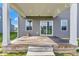 Covered wooden patio with steps down to the backyard and view of the homes in the community at 6305 Norwich Dr, Brownsburg, IN 46112