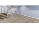 Finished basement with light blue walls and wood-look floors, leading up to the staircase to the main level at 641 E 33Rd St, Indianapolis, IN 46205