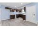 Bright kitchen with dark cabinets, gray countertop, vinyl flooring, and a white door at 641 E 33Rd St, Indianapolis, IN 46205