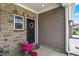 Welcoming front porch with a charming wreath, stone accents, and vibrant potted flowers at 6429 Yuma Ct, Whitestown, IN 46075