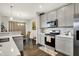 Modern kitchen with stainless steel appliances, white cabinets, and quartz countertops at 6429 Yuma Ct, Whitestown, IN 46075