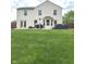 Spacious backyard with lush lawn, patio, dining set, hot tub, and fenced perimeter at 6550 Spring Flower Dr, Indianapolis, IN 46237