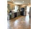 Modern kitchen with gray cabinets, black appliances, tile flooring, and an eat-in dining area at 6550 Spring Flower Dr, Indianapolis, IN 46237