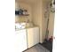 Functional laundry room with full-size washer and dryer, storage shelves, and cleaning supplies at 6550 Spring Flower Dr, Indianapolis, IN 46237