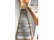 Carpeted staircase with wooden handrail, providing a safe and stylish transition between floors at 6550 Spring Flower Dr, Indianapolis, IN 46237