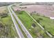 Expansive aerial view shows a grassy field bisected by a road next to a busy highway, ideal for various developments at 6585 N Waverly Park Rd, Martinsville, IN 46151