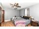 Bedroom features wood floors, a ceiling fan, gray walls, and natural light from a window at 6585 N Waverly Park Rd, Martinsville, IN 46151