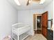 Bright bedroom featuring a white baby crib, neutral walls, and an open wooden door at 6585 N Waverly Park Rd, Martinsville, IN 46151