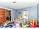 bedroom with a window and hardwood floors features blue walls and a collection of toys and stuffed animals at 6585 N Waverly Park Rd, Martinsville, IN 46151