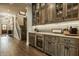 Stylish wet bar with gray cabinets, wine fridge, and marble countertops at 6734 W Stonegate Dr, Zionsville, IN 46077