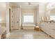 Open concept bathroom with a soaking tub, double vanity, and large window for natural light at 6734 W Stonegate Dr, Zionsville, IN 46077