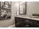Modern bathroom with dark cabinets, marble countertops, and automotive-themed decor at 6734 W Stonegate Dr, Zionsville, IN 46077