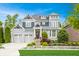 Stunning two-story home featuring a meticulously landscaped front yard and a three-car garage at 6734 W Stonegate Dr, Zionsville, IN 46077