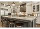Gourmet kitchen featuring a large island with marble countertops, stainless steel appliances, and modern lighting at 6734 W Stonegate Dr, Zionsville, IN 46077
