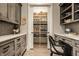 Well-organized pantry with gray cabinets, white countertops, and wooden floors at 6734 W Stonegate Dr, Zionsville, IN 46077