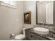 Stylish powder room features a dark granite countertop, oval sink, and decorative framed art at 6734 W Stonegate Dr, Zionsville, IN 46077