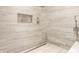 Modern shower with neutral colored tiling, niche storage, and a rainfall shower head at 6734 W Stonegate Dr, Zionsville, IN 46077