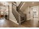 Elegant staircase with hardwood steps and white risers, complemented by stylish lighting fixtures at 6734 W Stonegate Dr, Zionsville, IN 46077