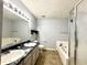This bathroom features a dual sink vanity with black countertops, a bathtub, and a separate shower at 6903 Governors Pointe Blvd, Indianapolis, IN 46217