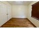 This bedroom features wood floors, a window with blinds, and a closet with double doors at 6903 Governors Pointe Blvd, Indianapolis, IN 46217