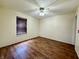 This bedroom features wood floors, a window with blinds, a ceiling fan, and neutral paint at 6903 Governors Pointe Blvd, Indianapolis, IN 46217