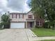 Two story home with brick and vinyl siding, red shutters, attached garage, and cloudy sky at 6903 Governors Pointe Blvd, Indianapolis, IN 46217
