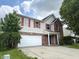 Two story home with brick and vinyl siding, red shutters, attached garage, and cloudy sky at 6903 Governors Pointe Blvd, Indianapolis, IN 46217